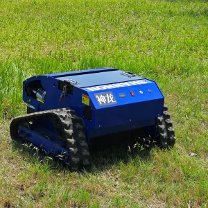 Blue SHANNON Shenlong remote-controlled tracked lawn mower with heavy-duty rubber tracks, control panel, and safety labels, designed for all-terrain slope and garden maintenance on green grass